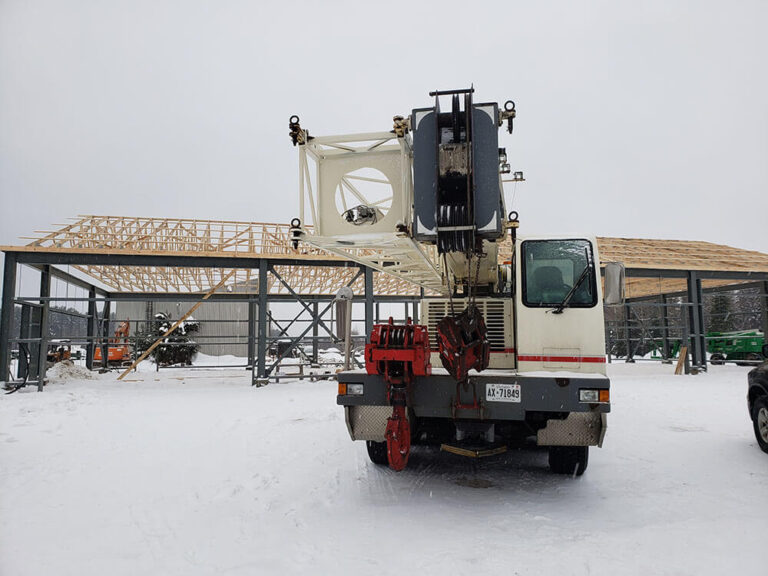 A picture of a crane operator, likely The Crane Guy himself, posing in front of a large industrial crane.