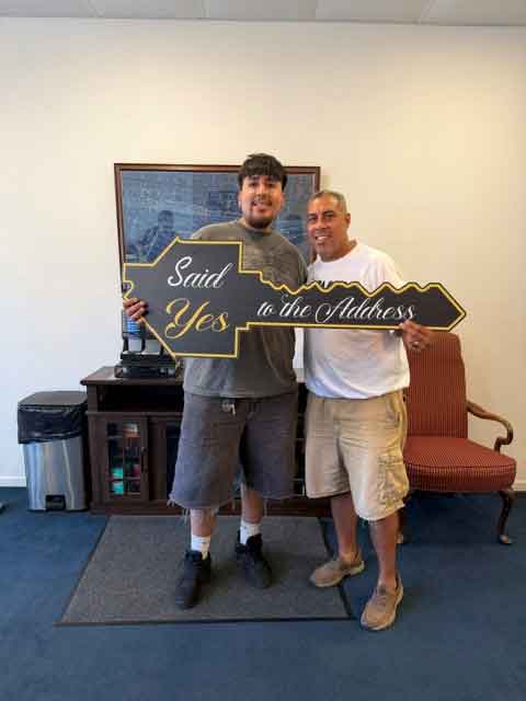 Randall Masri & Randall PC Digital team members holding a sign that says "Said Yes to the Address"