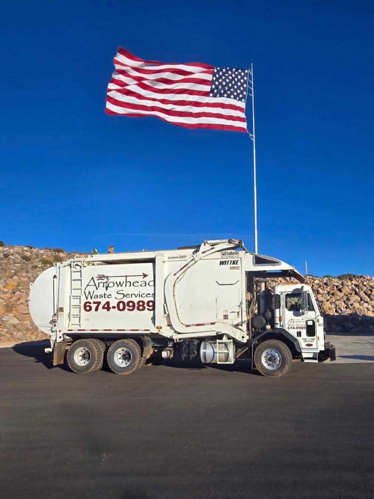 Arrowhead Waste commercial service truck beneath an American flag