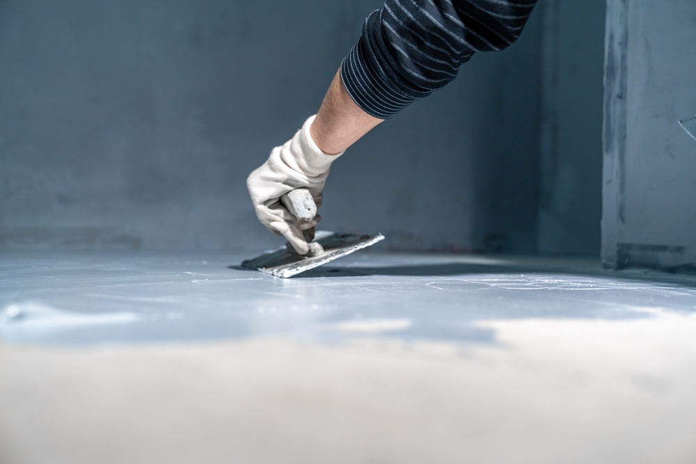 Avacrete Construction Ltd contractor troweling and applying concrete on a smooth floor surface