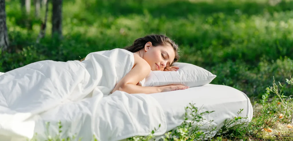 A person sleeping on a mattress in a bedroom setting, looking relaxed and comfortable.