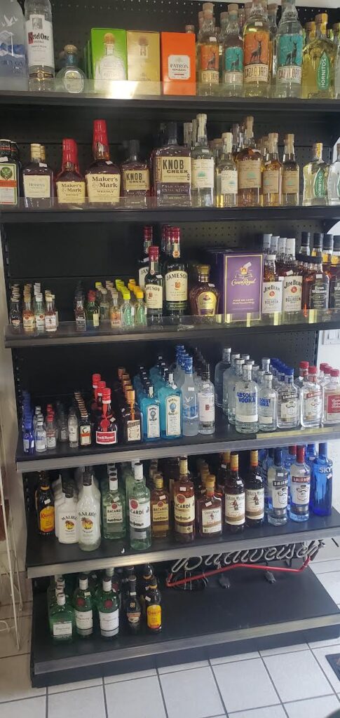 Assorted liquor bottles on shelves at Winchester 76 & Market convenience store