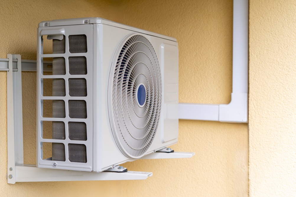 Rick's Heating & Air Conditioning Inc. HVAC air conditioner unit installed on exterior wall