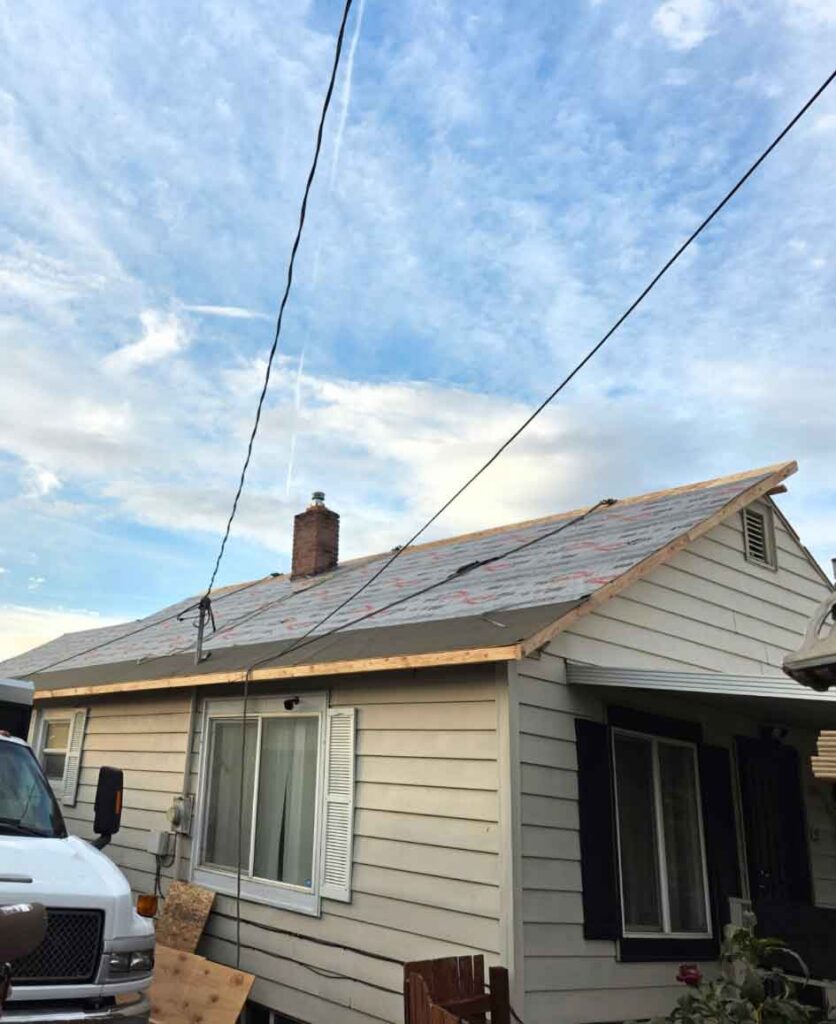 A+ Quality Construction exterior roof repair with new shingles and chimney on a residential house