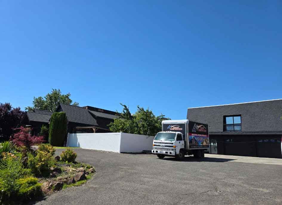 A+ Quality Construction work truck parked in front of a residential property driveway