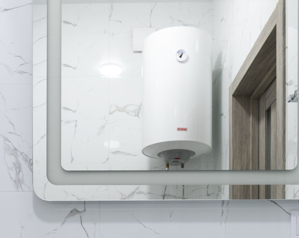Sechelt Plumbing installing a wall-mounted water heater in a modern bathroom