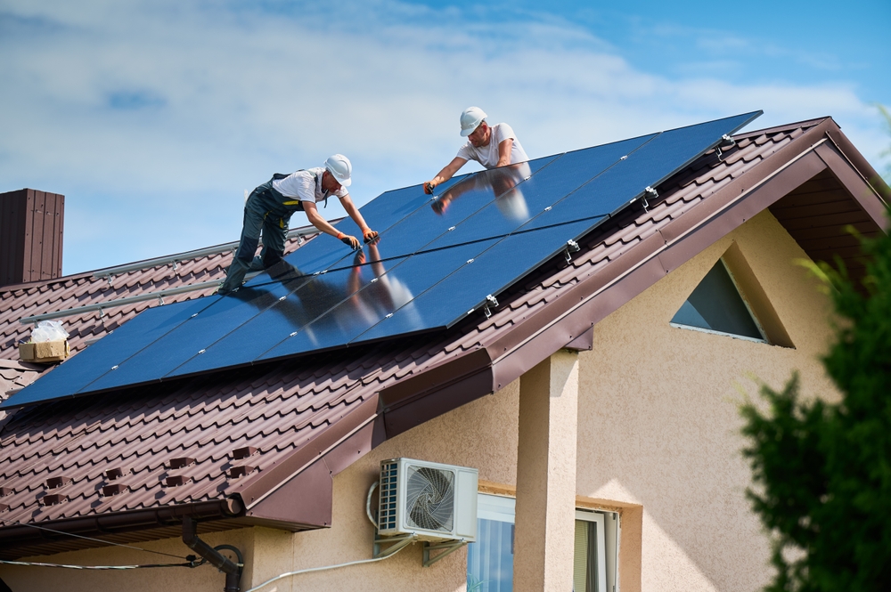 Light Of This World Electric technicians installing solar panels on a residential roof