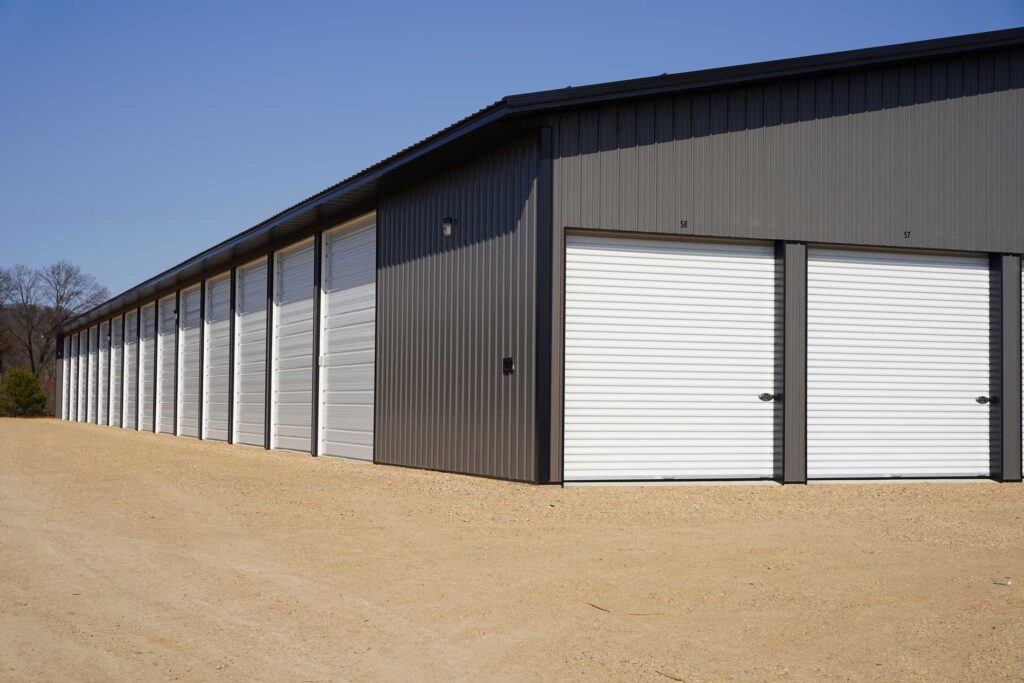 AmCo Door Co. exterior view of a commercial metal building with multiple roll-up garage doors
