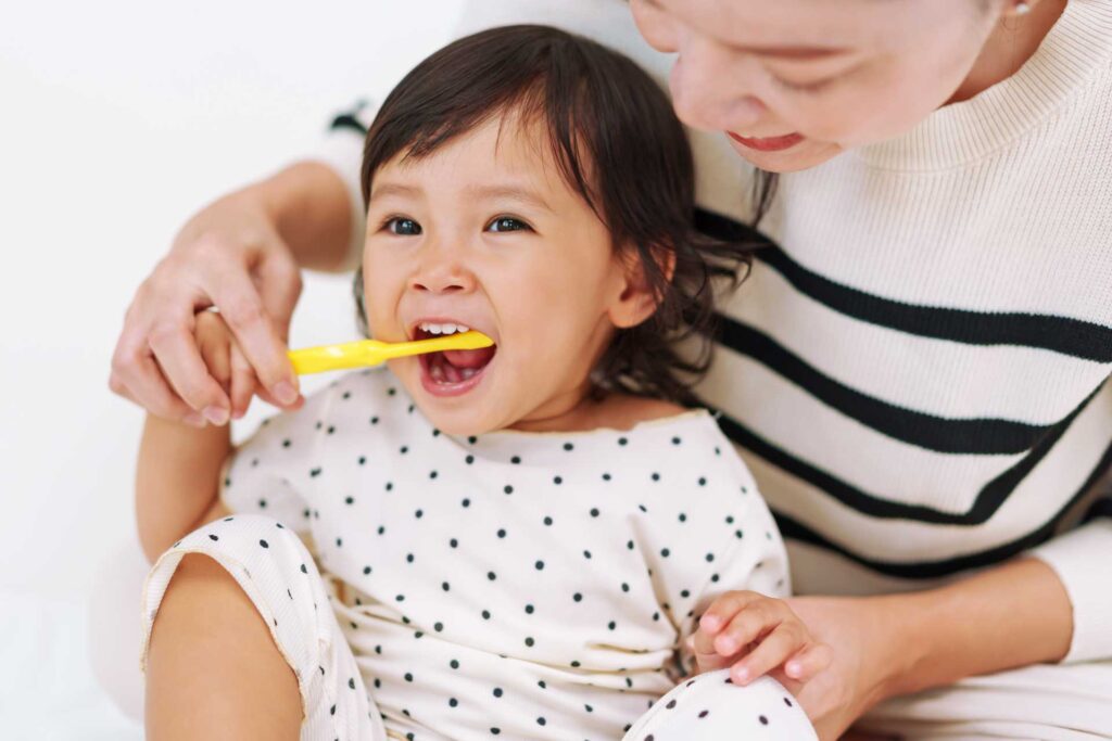 mother daughter brushing teeth