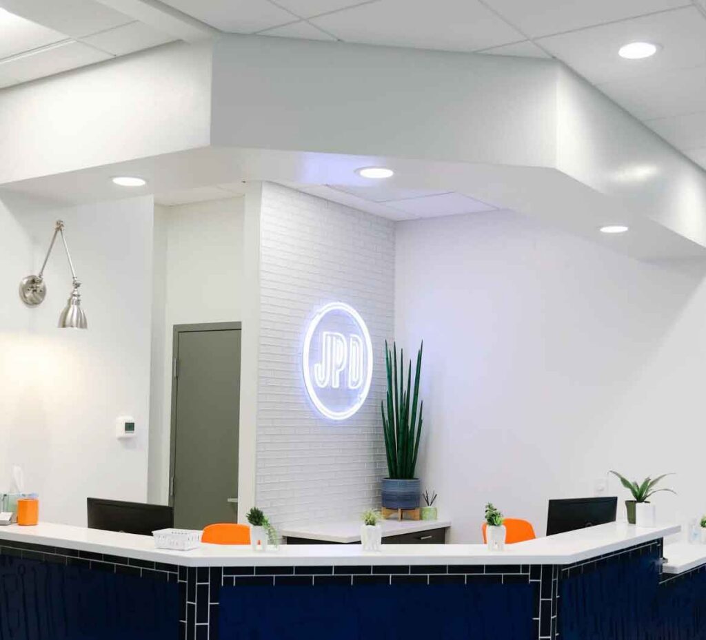 Johnson Pediatric Dentistry reception area with neon logo sign