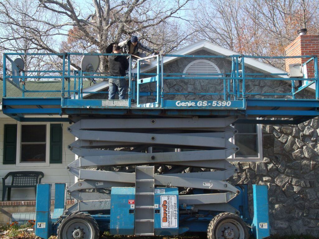 Team Boyd's Custom Remodeling uses scissor live to reach roofing and fascia of home Millford DE