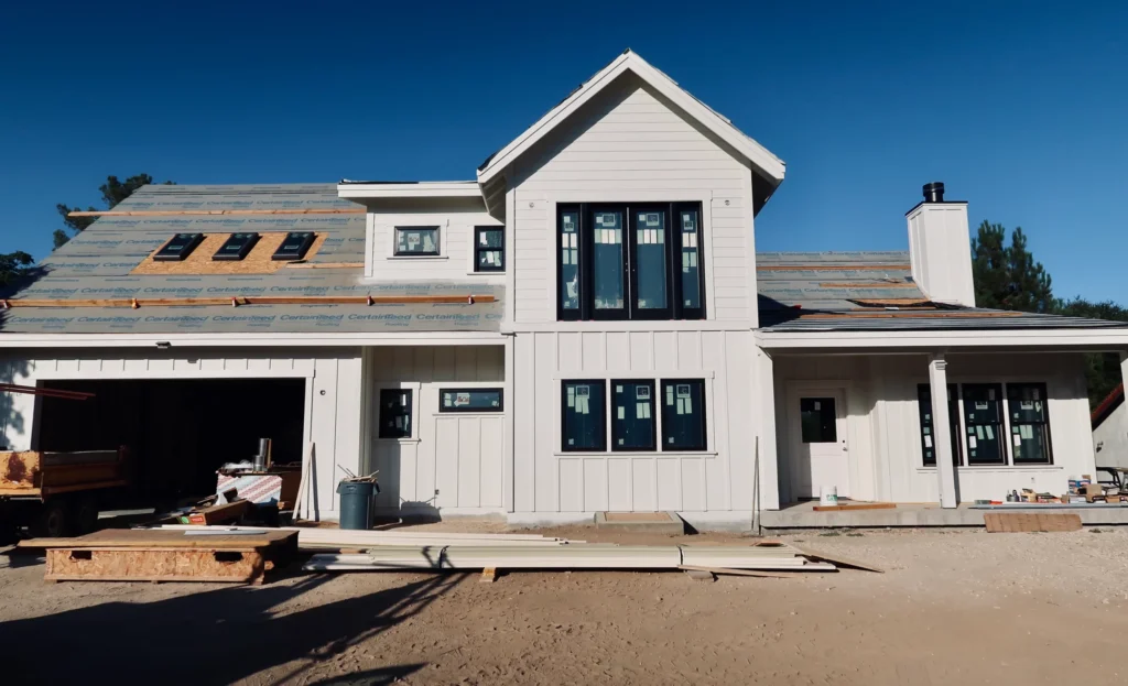 Nielsen Building Materials Inc. construction site showing a newly built home exterior with windows and roof framing