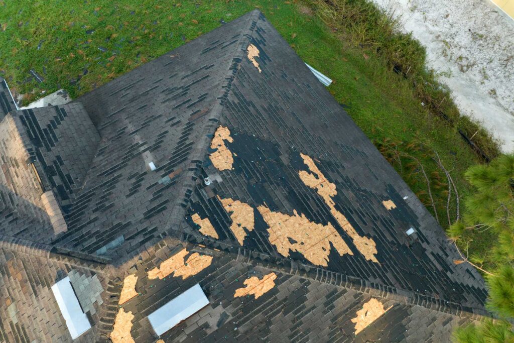 Damaged shingle roof with exposed underlayment, roof repair by JN Roofing