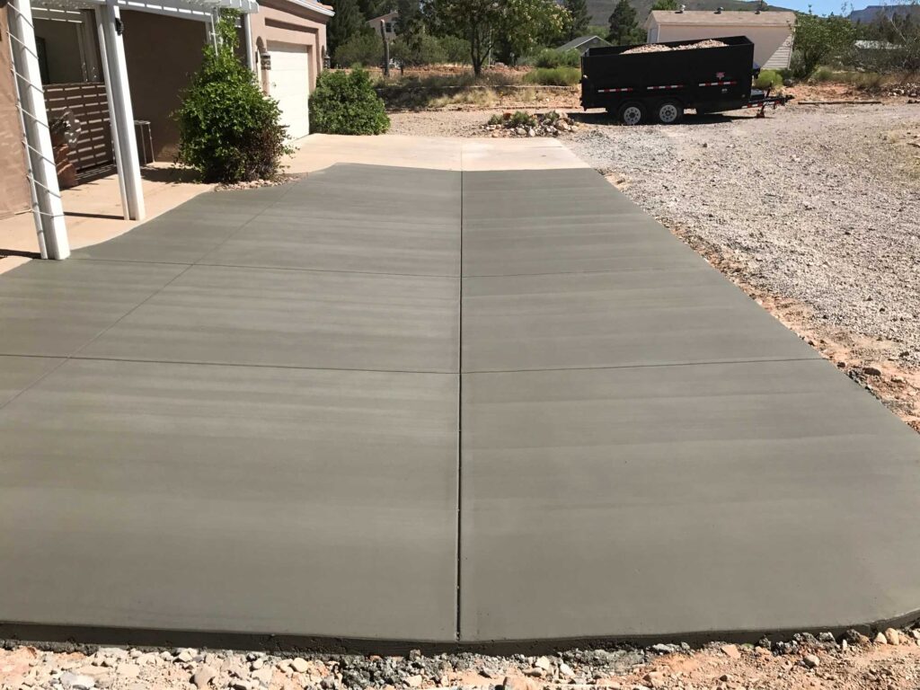 New concrete driveway installation by Jensen's Quality Concrete Inc. with concrete truck in background