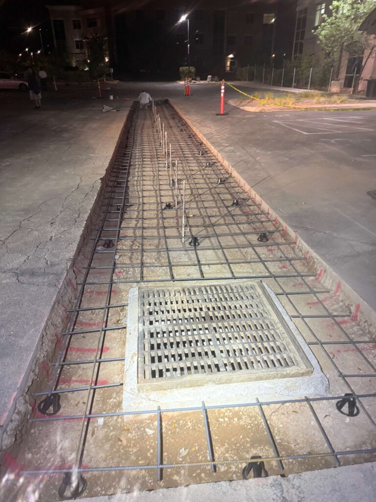 Jensen's Quality Concrete construction site at night with rebar reinforcement and concrete forms