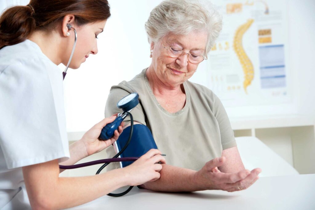 Healthcare professional checking a senior woman's blood pressure with a stethoscope, representing Cole Insurance Agency LLC