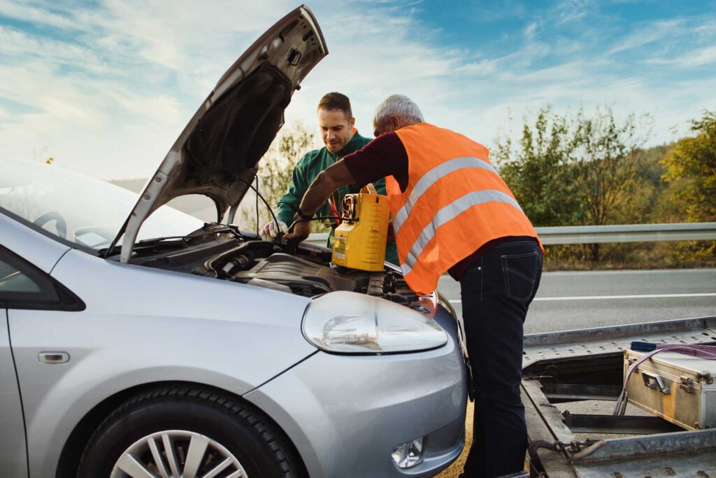 Cole Insurance Agency LLC team assisting with roadside service and checking a car engine