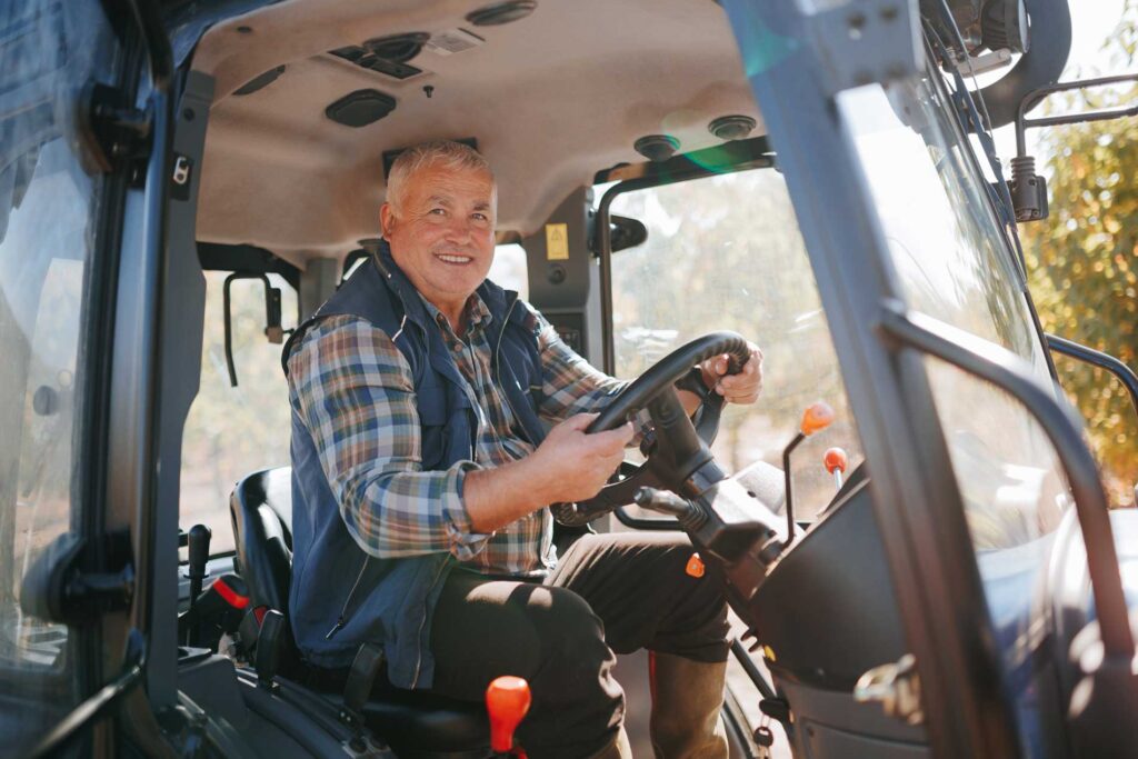 Smiling truck driver in a vehicle with steering wheel, representing Cole Insurance Agency LLC