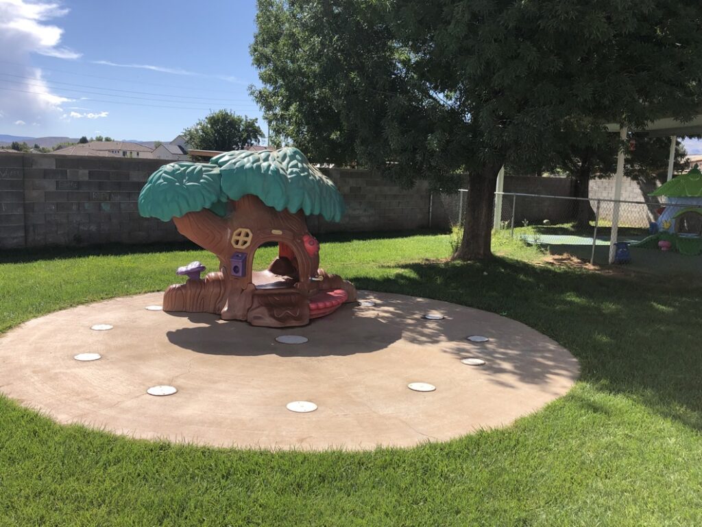 Outdoor play area of Country Kids Children’s Center with a jungle-themed play structure and artificial turf