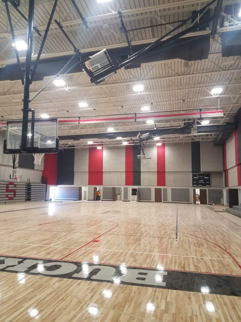 Indoor basketball gym ceiling with lighting and electrical fixtures, provided by Marshall & Evans Electric Inc.