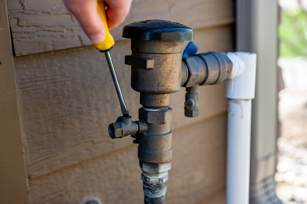 Mid-Coast Fire Protection technician adjusting an outdoor fire protection system valve
