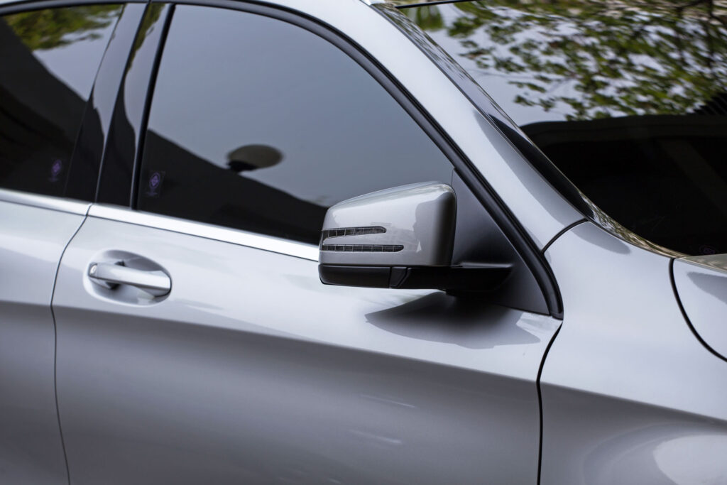 Mobile window tinting on a car door and side mirror