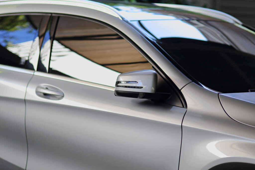 Close-up of a car side window with window tint applied by Mobile Window Tinting Co.