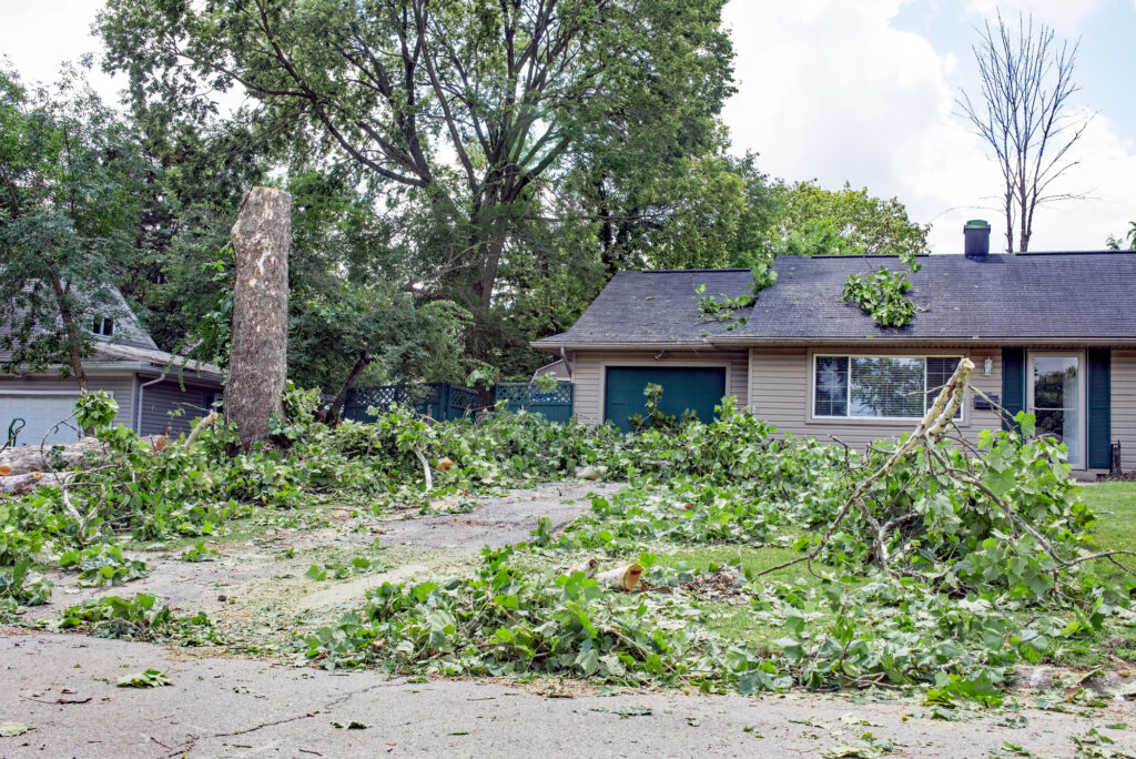 Storm-damaged tree and debris in front of a home for Southwest Missouri Tree Service
