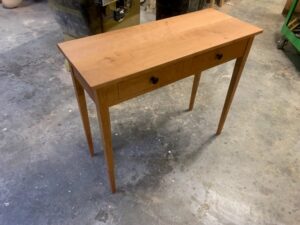 Handcrafted wooden desk with routed heart drawer pulls in a workshop by Jim's Wood Furniture & CNC Routing