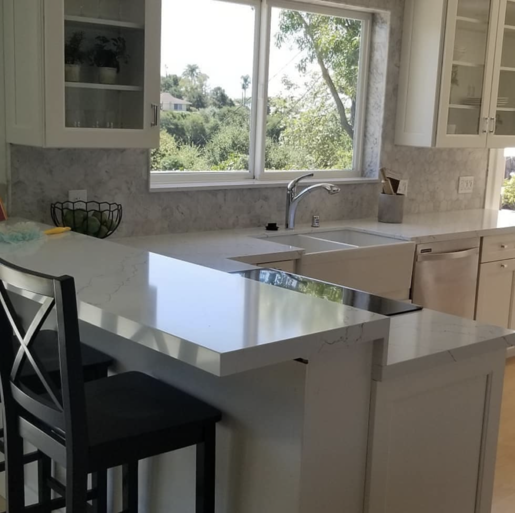 Modern kitchen remodel by Brasil Stone Home Improvements, Inc. with white countertops and sink
