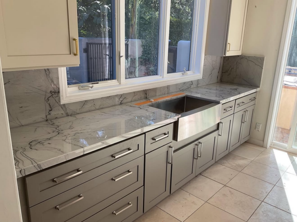 Kitchen countertop installation with marble backsplash and custom cabinetry by Brasil Stone Home Improvements, Inc.