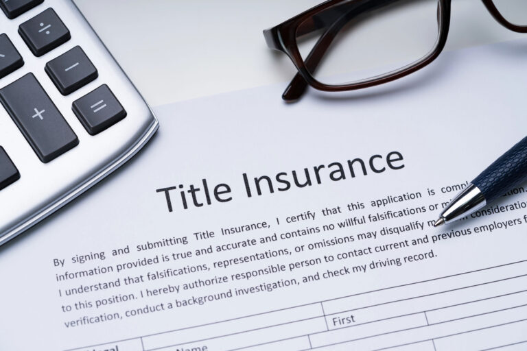 Barton County Title Co Inc. title insurance document with calculator and pen