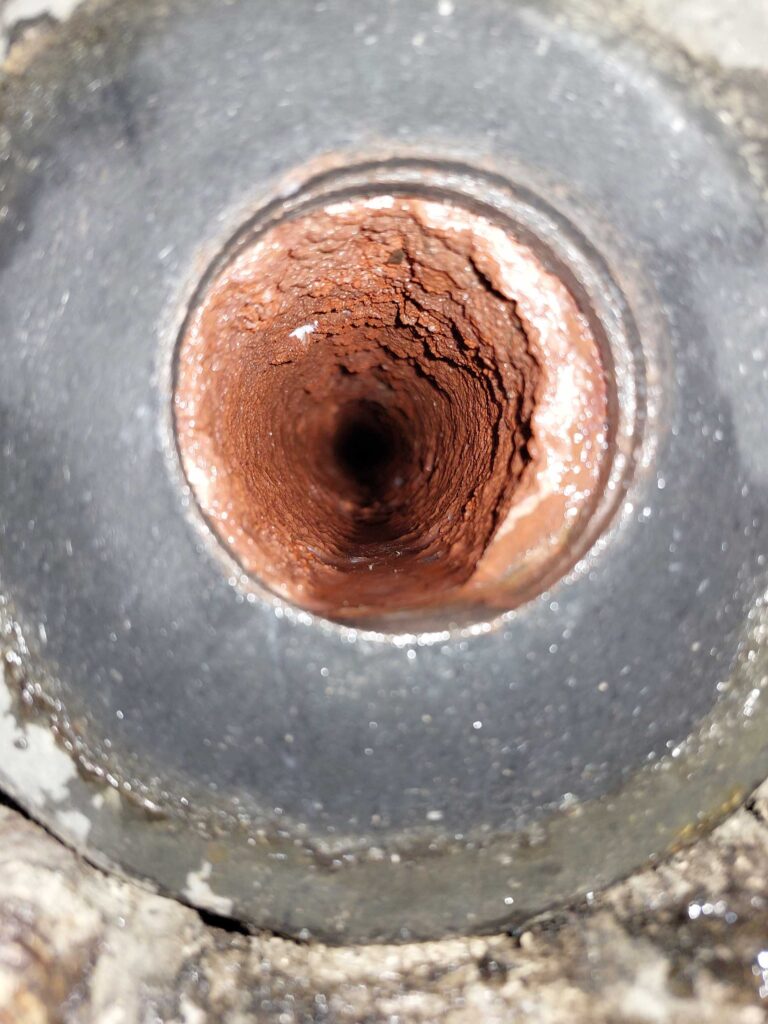 Close-up of a clogged sewer pipe interior with rust and debris, inspected by Skagit Sewer Specialists