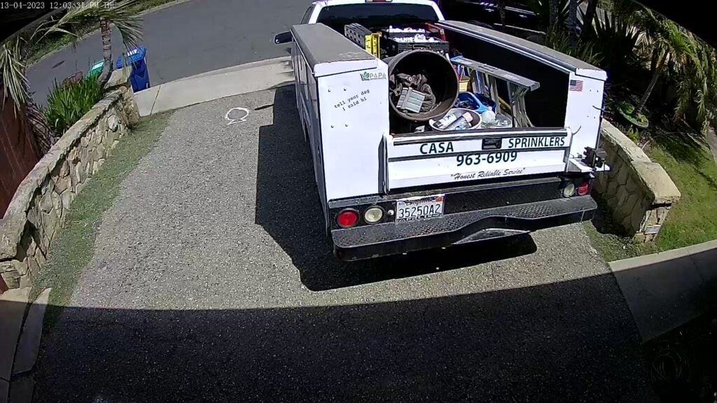 Casa Landscape Maintenance service truck with sprinklers on a residential street
