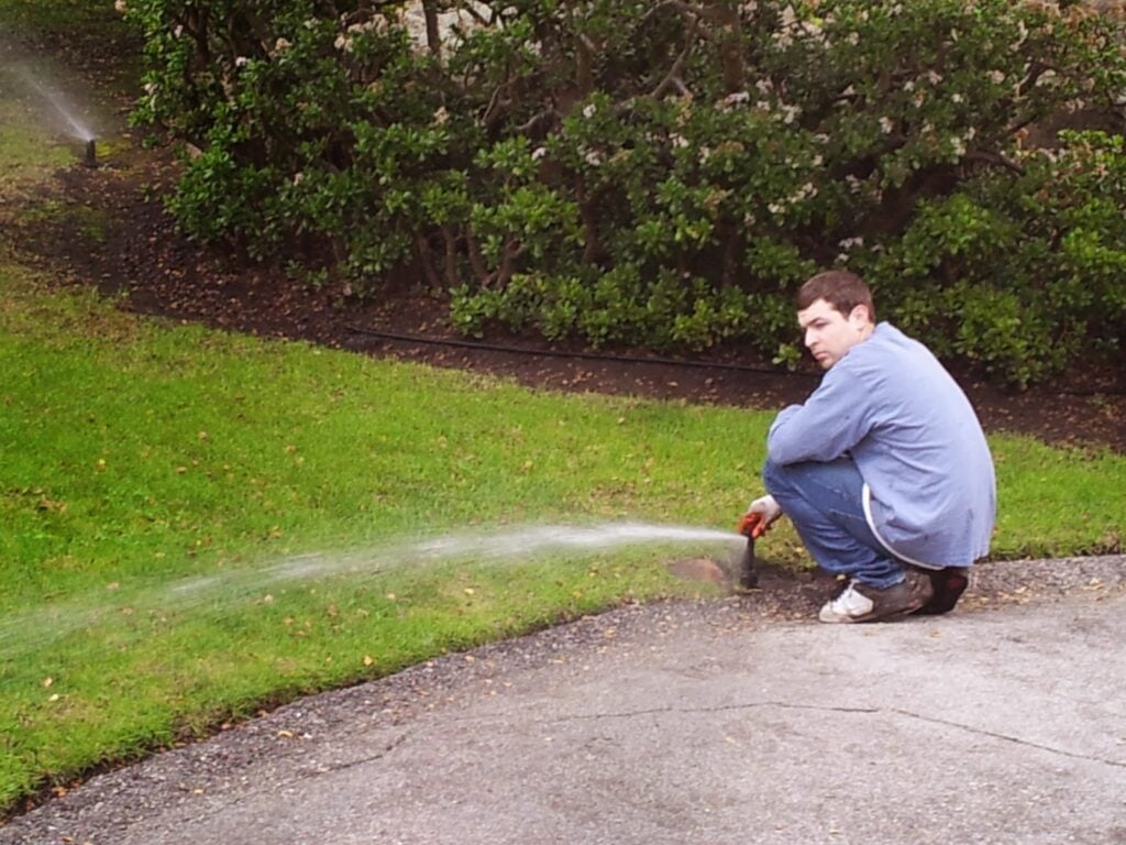 Technician pressure washing landscaping edging for Casa Landscape Maintenance