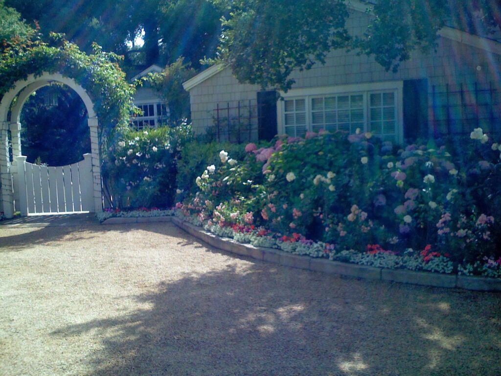 Casa Landscape Maintenance front yard garden with flower beds and archway