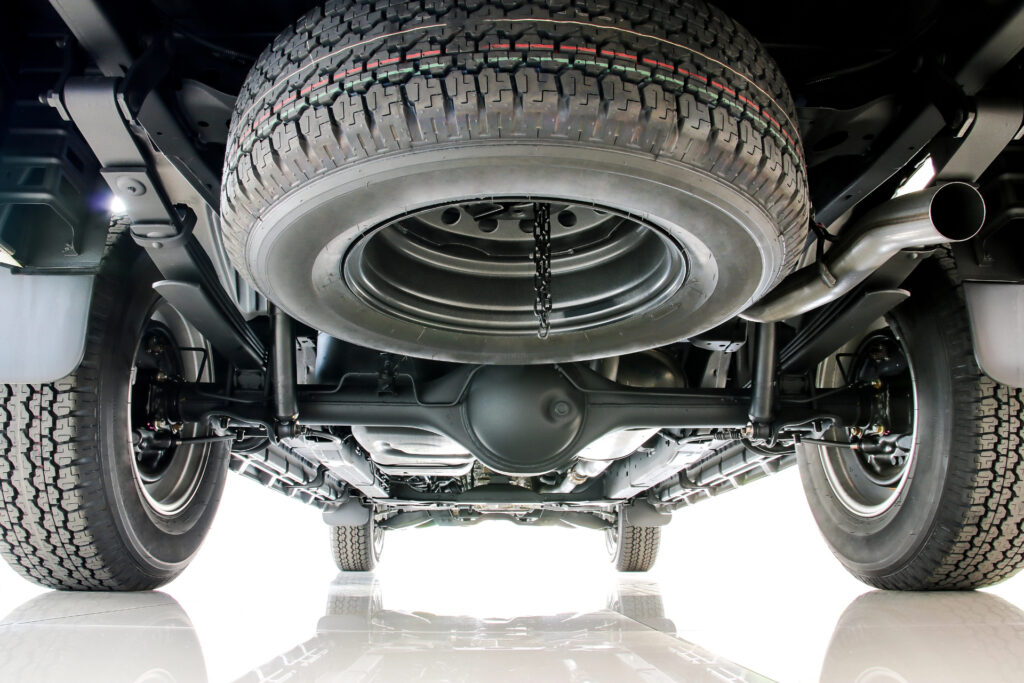 View from underneath a truck showing the rear axle and tires