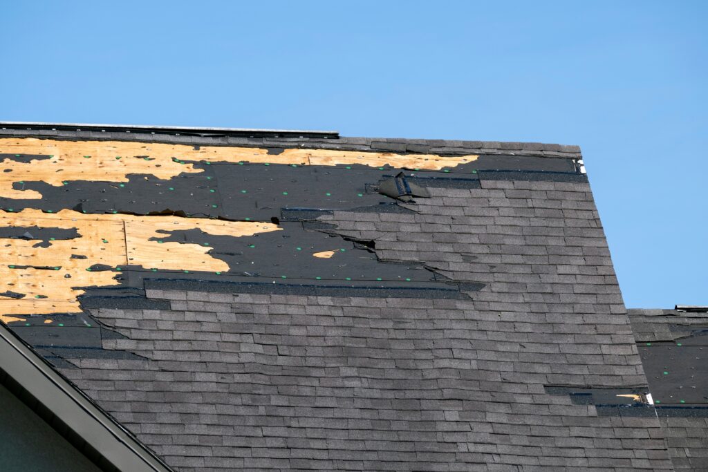 A close-up of a gray asphalt shingle roof before and after installation, demonstrating the transformation from old to new.
