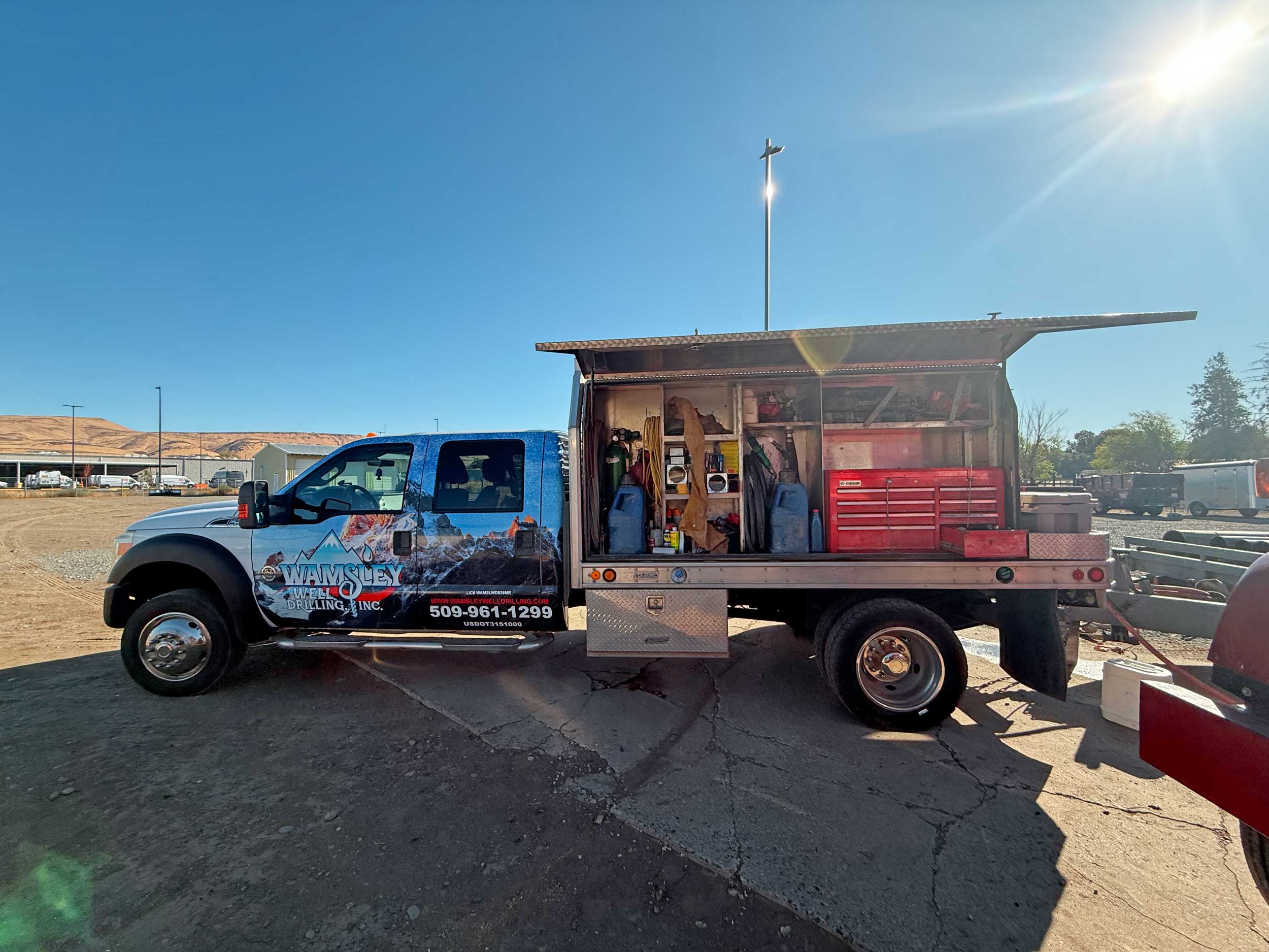 Wamsley Well Drilling Inc. service truck with tools and equipment in open work bay