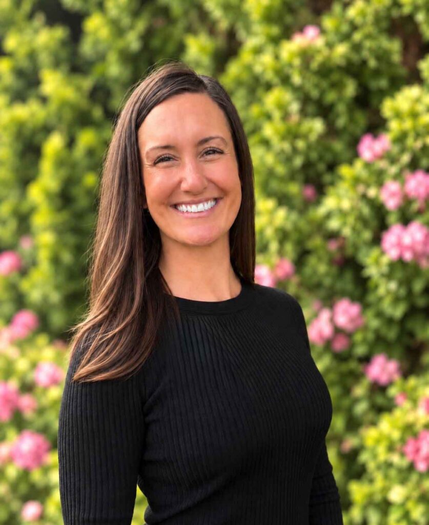 Boise Valley Chiropractic team member portrait outdoors with green foliage and pink flowers
