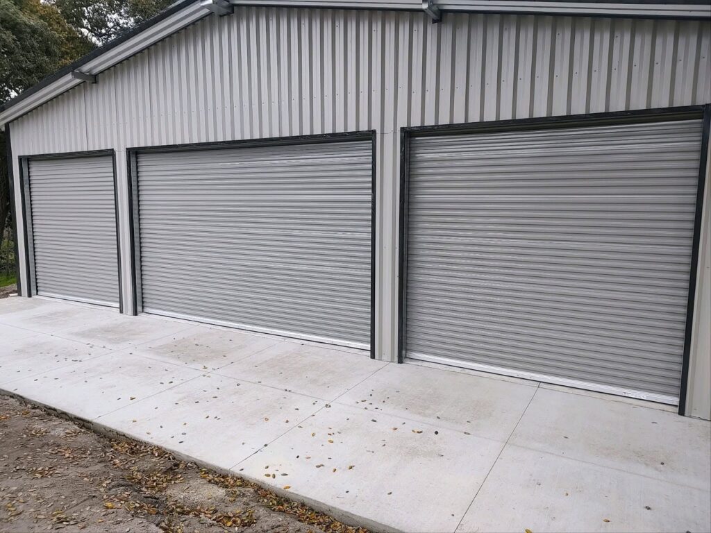Pacific Overhead Door Service image of multiple closed roll-up overhead garage doors on a metal building