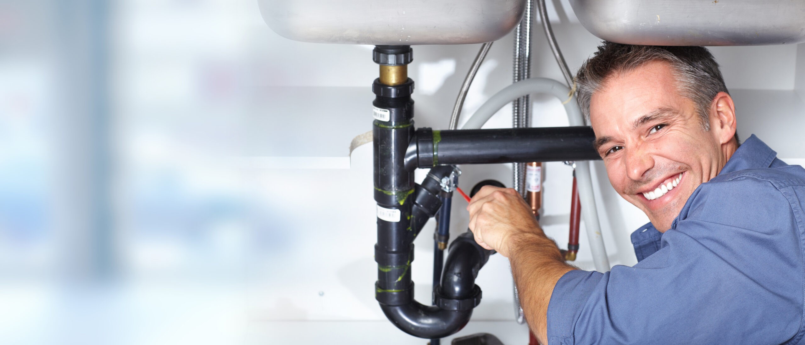 Plumbing system pipes and fittings under a sink