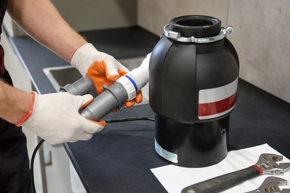 Technician installing a garbage disposal for Complete Plumbing Services LLC