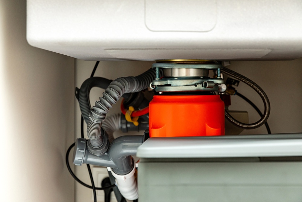 Complete Plumbing Services LLC garbage disposal installation with plumbing pipes under a sink