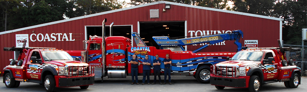 front of building and 3 trucks, Coastal Towing team